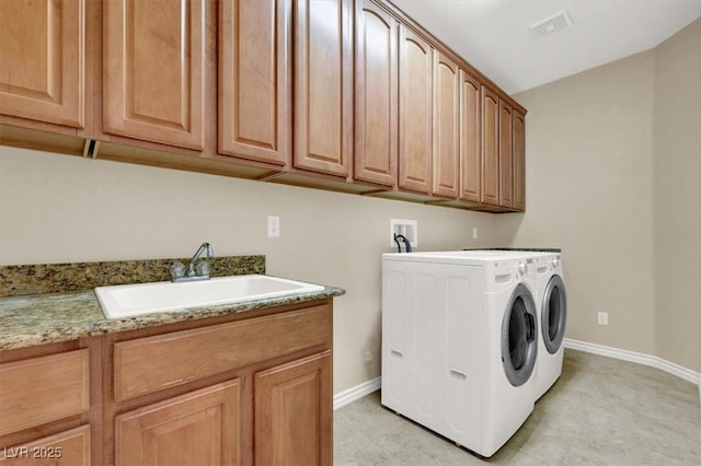 washroom featuring separate washer and dryer, sink, and cabinets