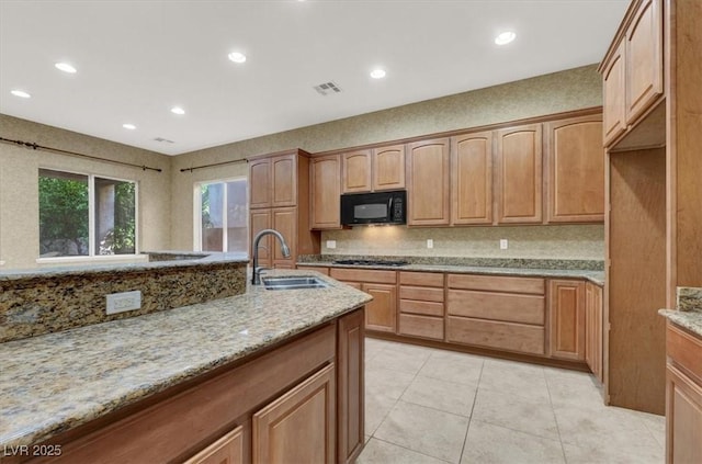 kitchen with sink, gas cooktop, light stone counters, light tile patterned flooring, and decorative backsplash