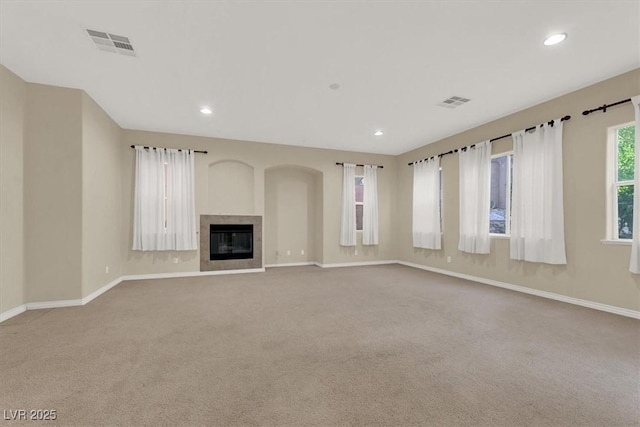 unfurnished living room with light colored carpet and a fireplace