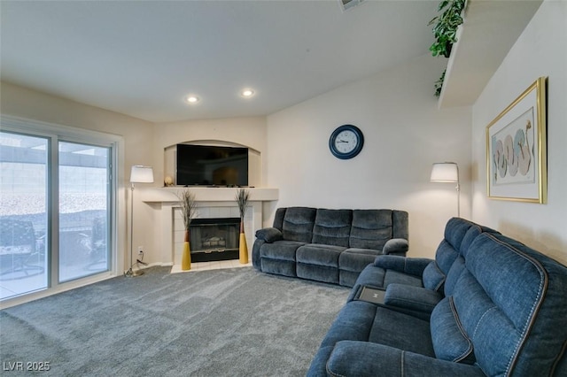 carpeted living room featuring a tile fireplace