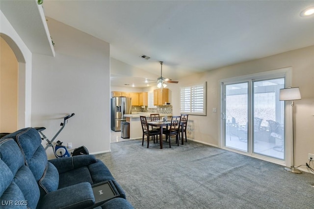 carpeted living room featuring ceiling fan and vaulted ceiling