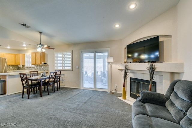 living room with ceiling fan, light colored carpet, lofted ceiling, and a fireplace