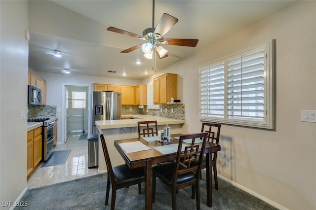 carpeted dining room with ceiling fan