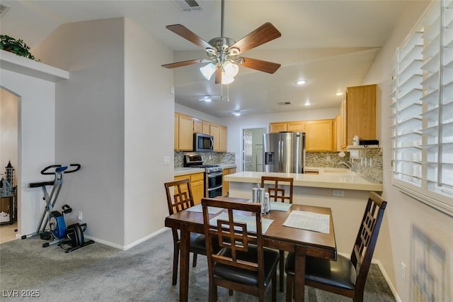 dining area featuring sink, light colored carpet, and ceiling fan