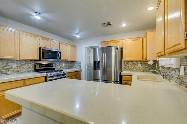 kitchen featuring light brown cabinetry, sink, backsplash, and appliances with stainless steel finishes