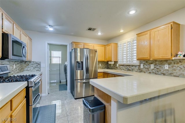 kitchen featuring sink, light brown cabinets, kitchen peninsula, stainless steel appliances, and decorative backsplash