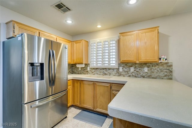 kitchen with sink, decorative backsplash, light tile patterned floors, and stainless steel refrigerator with ice dispenser