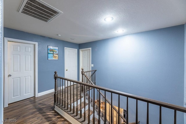 hallway with dark wood-type flooring and a textured ceiling