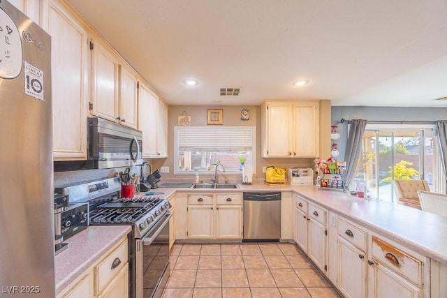 kitchen with stainless steel appliances, light tile patterned flooring, and sink