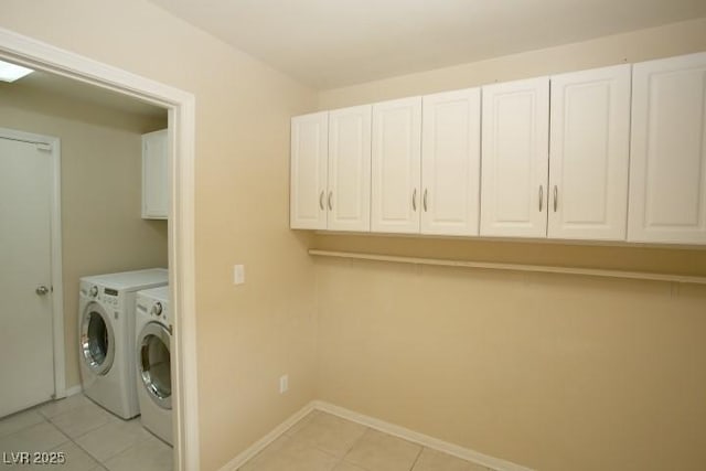 laundry room with cabinets, light tile patterned floors, and independent washer and dryer