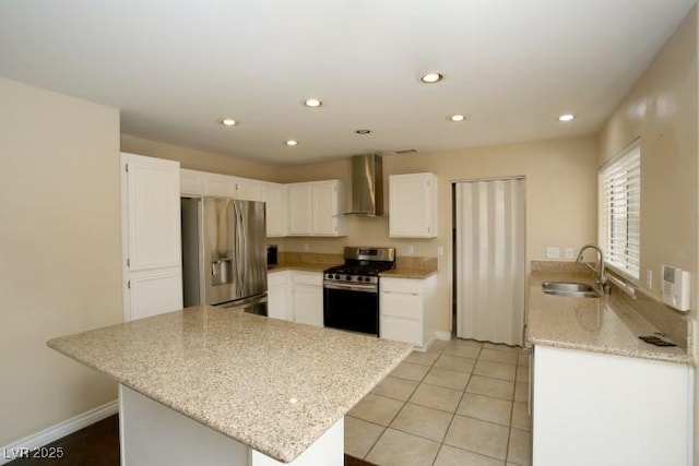 kitchen with wall chimney range hood, sink, stainless steel appliances, white cabinets, and kitchen peninsula