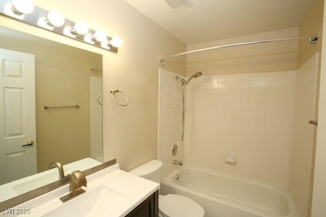 full bathroom with vanity, tiled shower / bath combo, and toilet