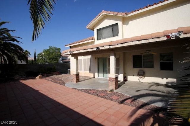 back of house with ceiling fan and a patio area