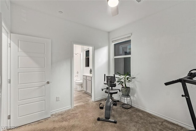 workout room featuring light colored carpet and ceiling fan