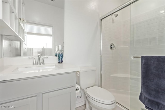 bathroom with vanity, a shower with shower door, and toilet