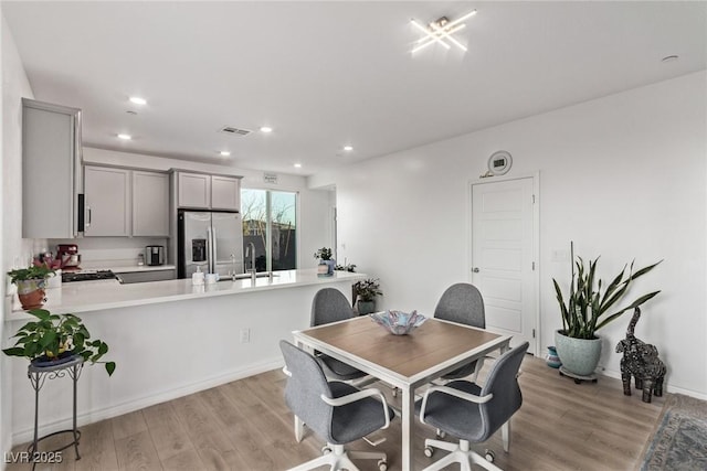 dining area featuring sink and light hardwood / wood-style flooring