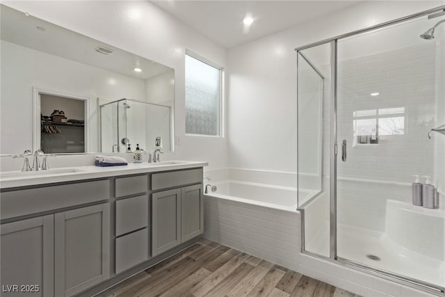 bathroom featuring shower with separate bathtub, hardwood / wood-style floors, and vanity