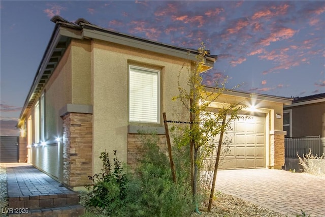 property exterior at dusk featuring a garage