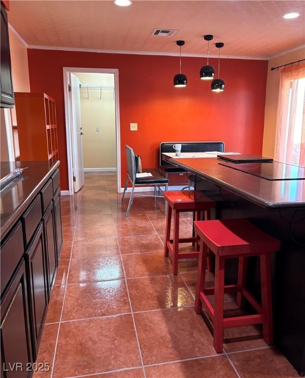 dining area featuring crown molding and tile patterned flooring