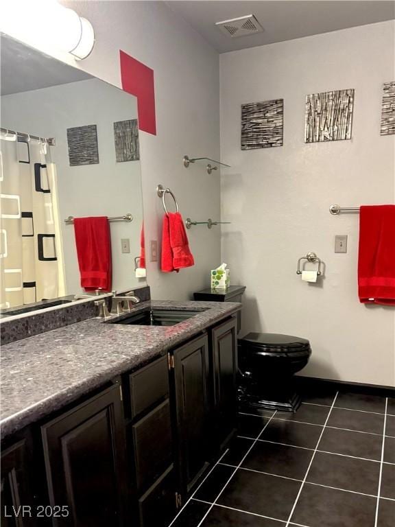 bathroom with tile patterned flooring, vanity, and toilet