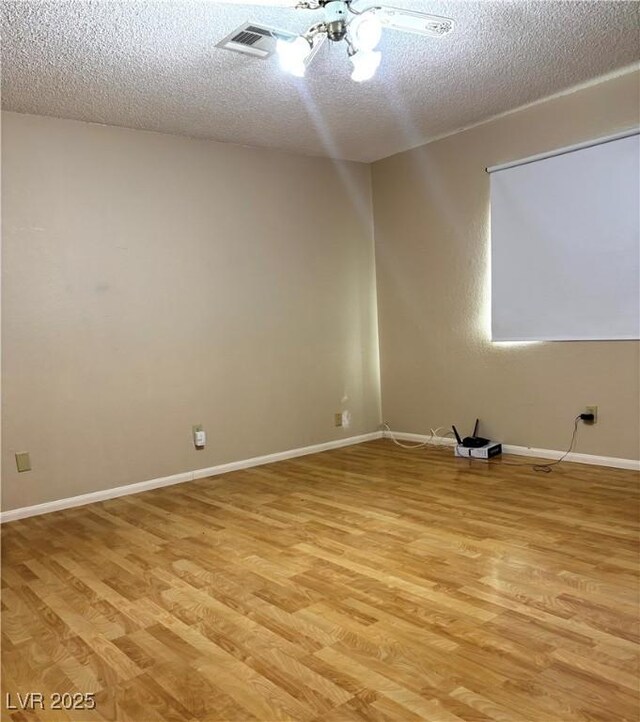 unfurnished room with light hardwood / wood-style floors and a textured ceiling