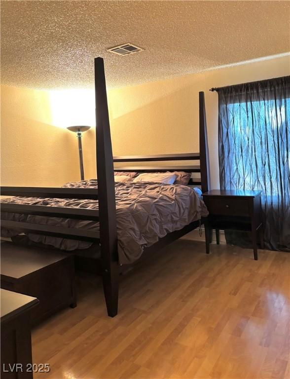 unfurnished bedroom featuring wood-type flooring and a textured ceiling