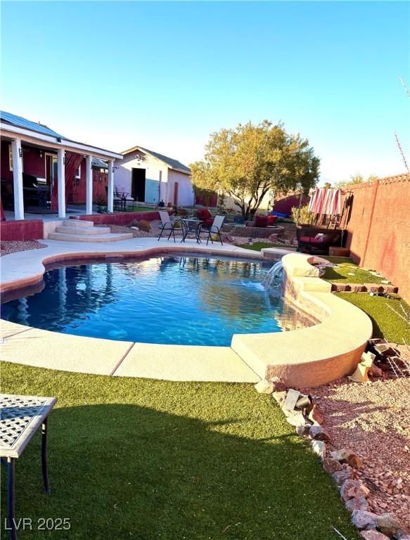 view of pool with a patio, a yard, and pool water feature