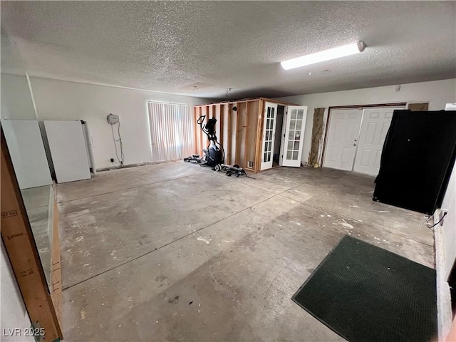 basement featuring a textured ceiling and white refrigerator