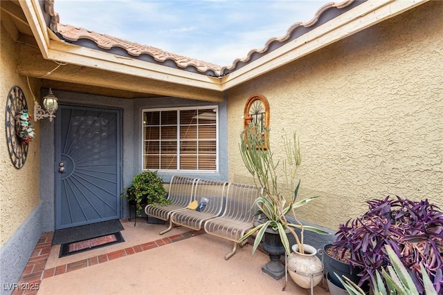 view of exterior entry with a patio area