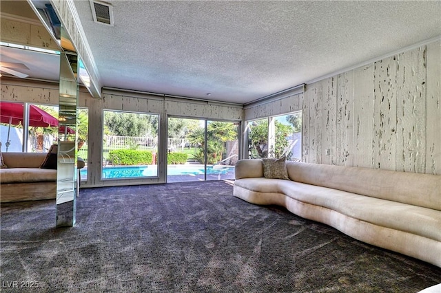 unfurnished living room featuring a textured ceiling and carpet flooring