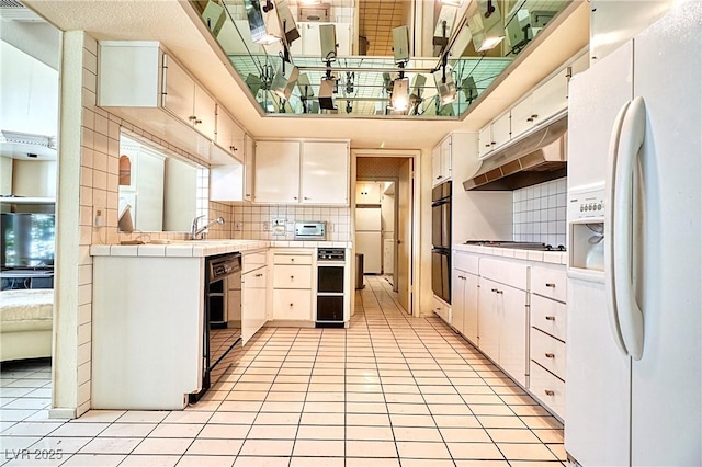 kitchen featuring white cabinetry, backsplash, black double oven, white refrigerator with ice dispenser, and light tile patterned floors