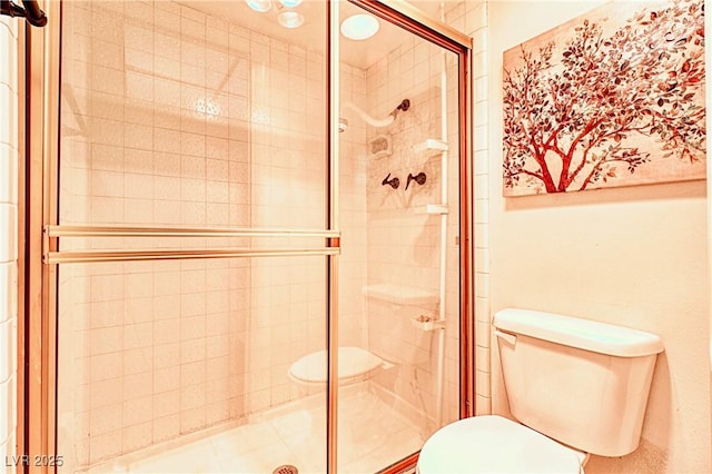 bathroom with a shower with shower door and toilet