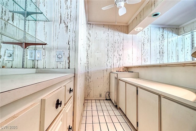 interior space featuring light tile patterned floors, ornamental molding, and ceiling fan