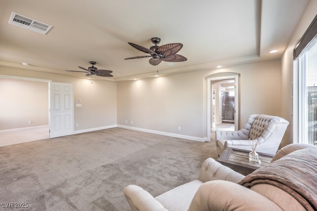 carpeted living room with ceiling fan