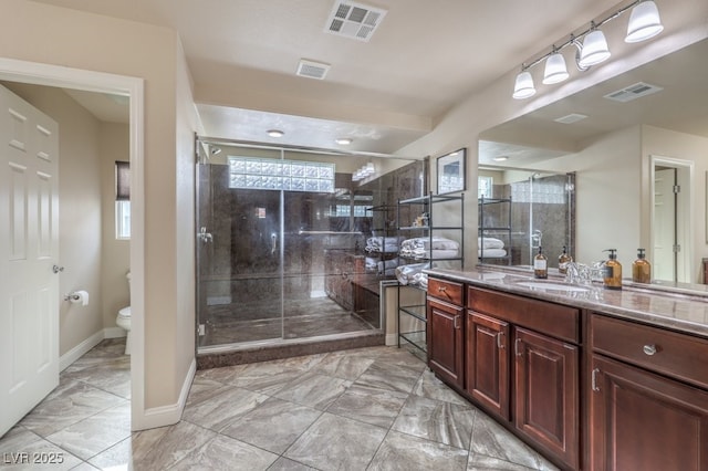 bathroom with vanity, a shower with door, and toilet