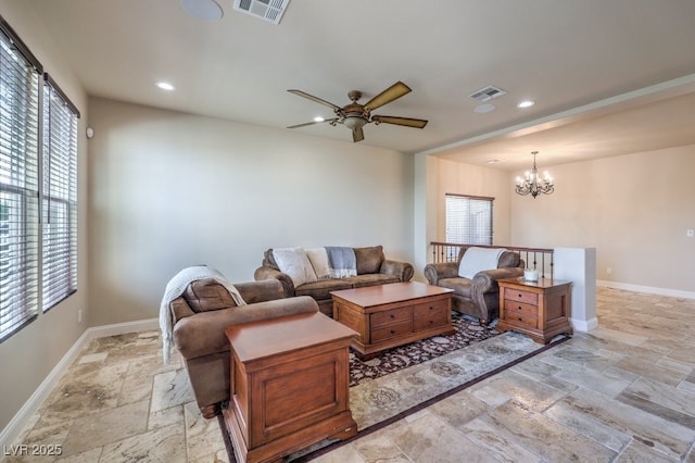 living room with ceiling fan with notable chandelier