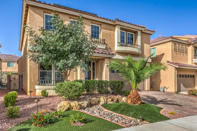 mediterranean / spanish-style home featuring a garage and a balcony