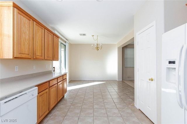 kitchen with pendant lighting, light tile patterned floors, white appliances, and a chandelier