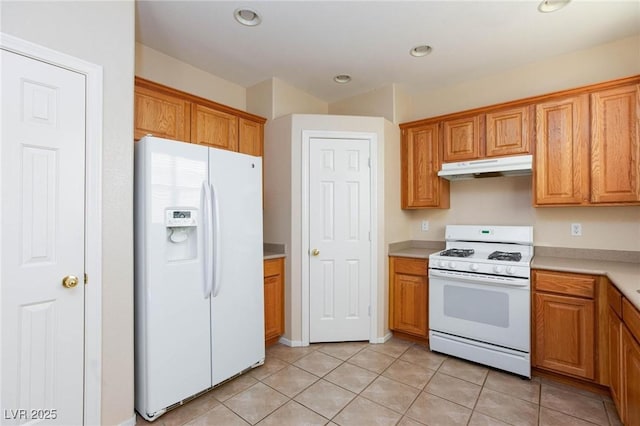 kitchen featuring light tile patterned floors and white appliances