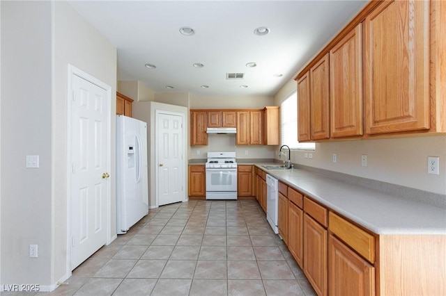 kitchen with white appliances, sink, and light tile patterned floors