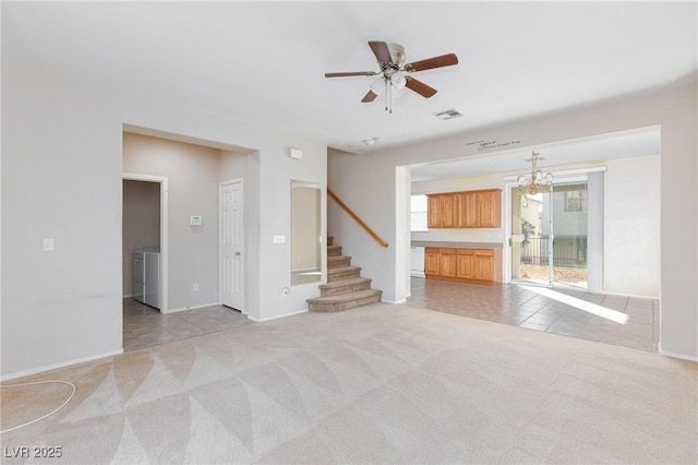 unfurnished living room featuring light carpet, washing machine and dryer, and ceiling fan