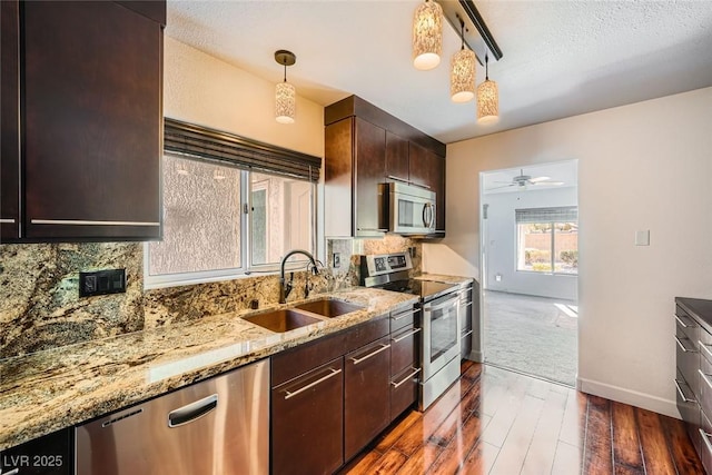 kitchen with stainless steel appliances, tasteful backsplash, sink, and pendant lighting