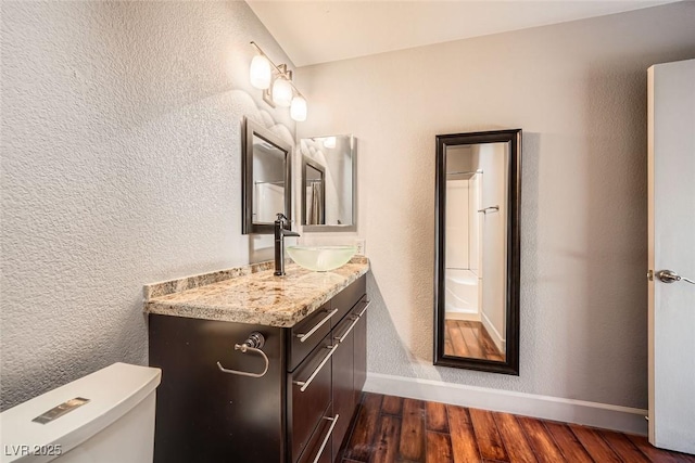 bathroom featuring vanity, hardwood / wood-style floors, and toilet