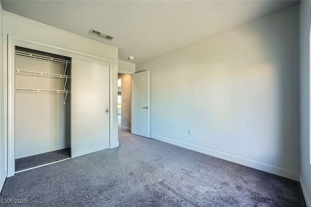 unfurnished bedroom featuring a closet and dark colored carpet