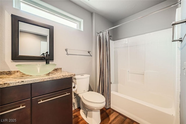 full bathroom with hardwood / wood-style flooring, vanity, shower / tub combo with curtain, and toilet