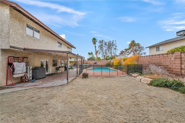 view of yard with french doors, a fenced in pool, and a patio area