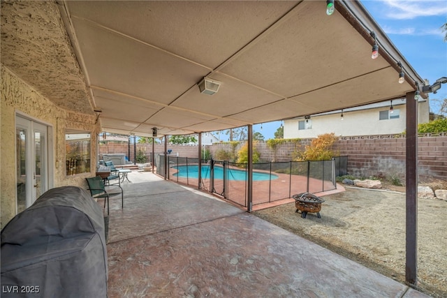 view of swimming pool with french doors, an outdoor fire pit, and a patio area