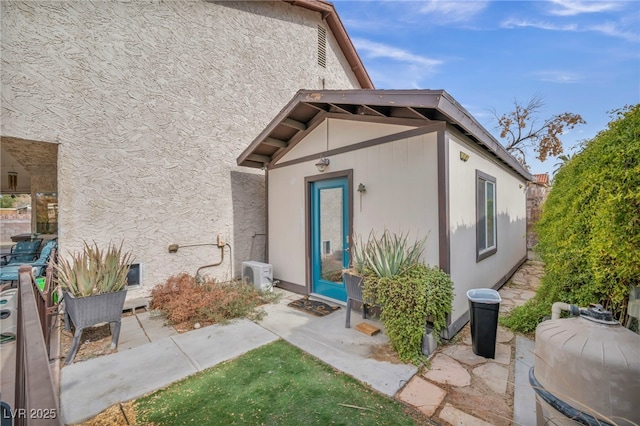 doorway to property with ac unit and a patio