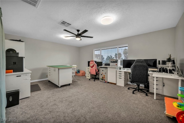 office area with a textured ceiling, light colored carpet, and ceiling fan