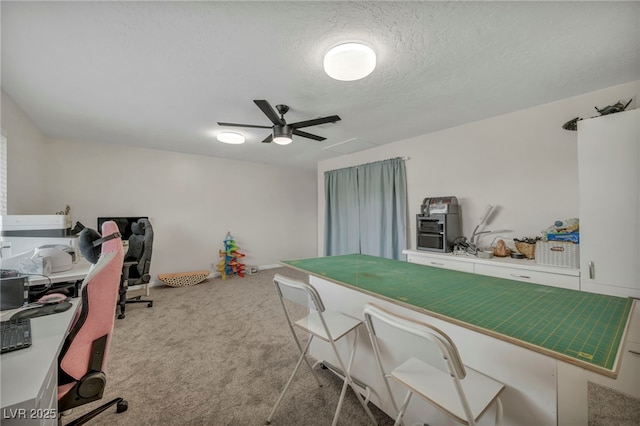 home office with ceiling fan, carpet flooring, and a textured ceiling